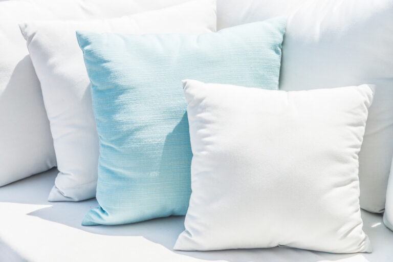 Pastel blue and white decorative pillows on couch.