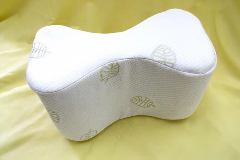 Ergonomic pillow with leaf pattern on yellow background.