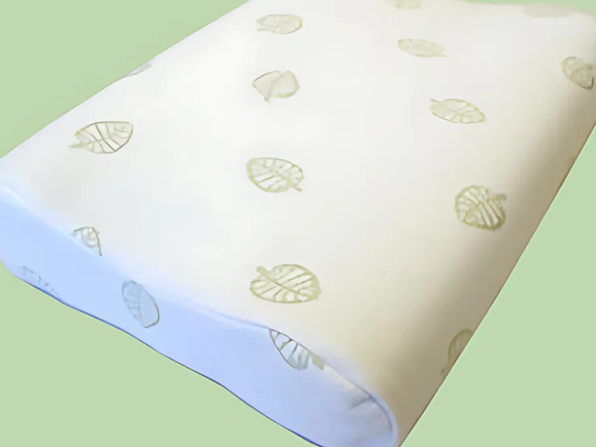 Leaf-patterned memory foam pillow on green background.
