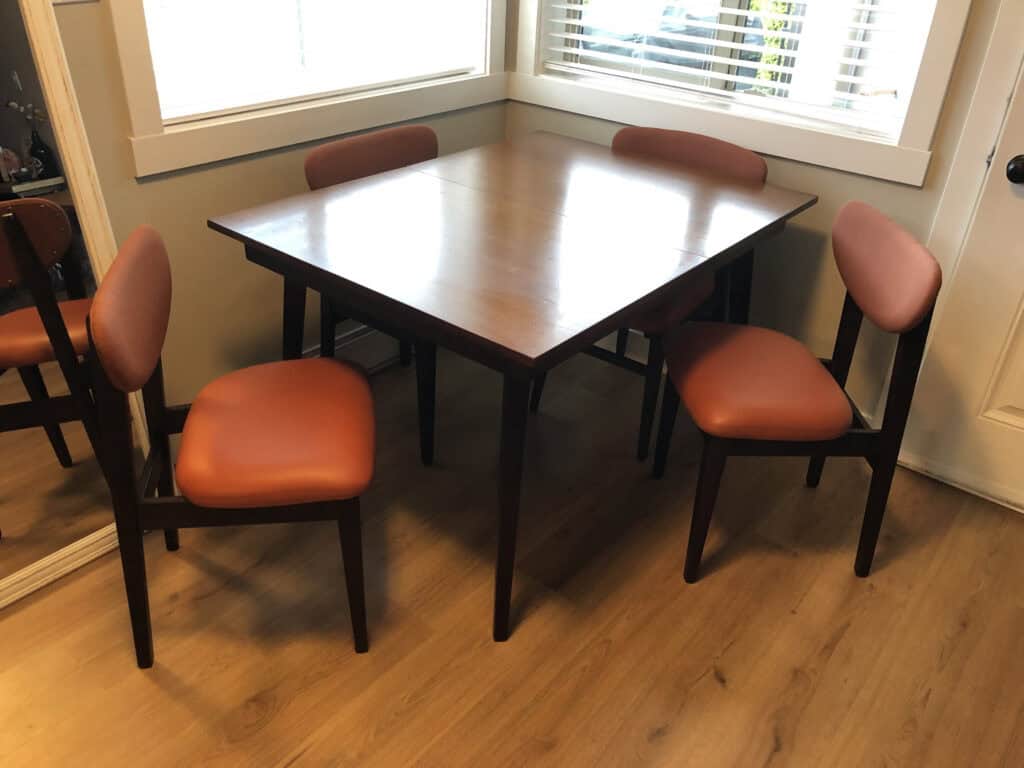 Wood table with four orange upholstered chairs