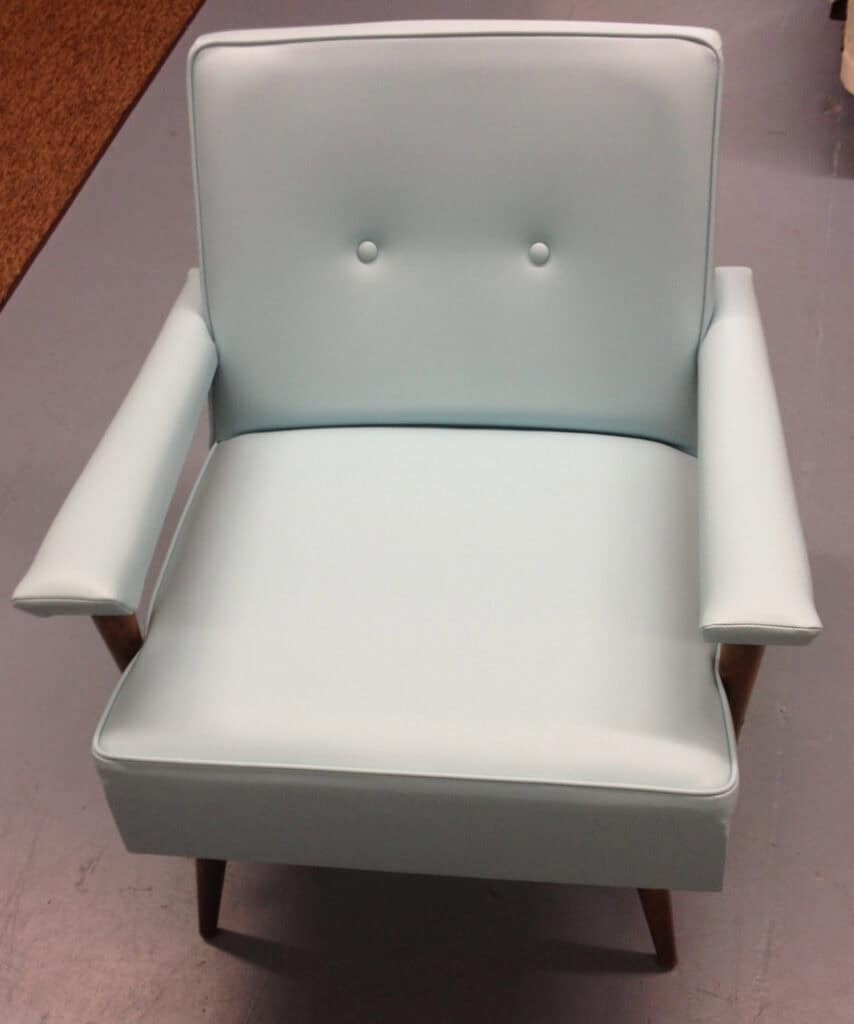 Light blue armchair with buttoned backrest.