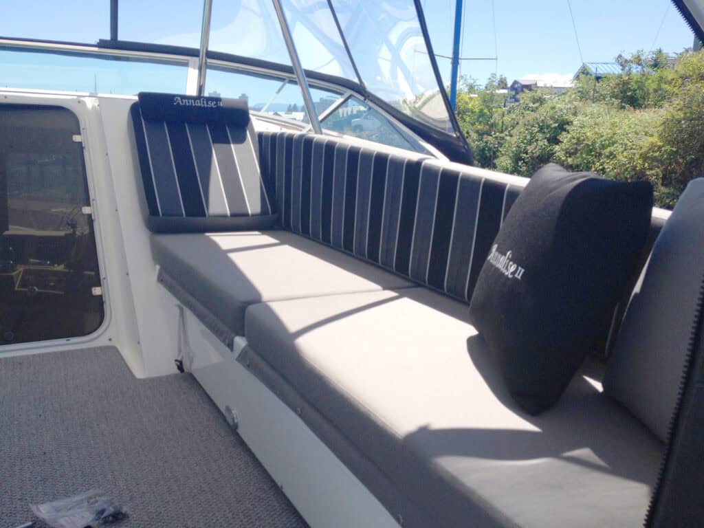Sunlit boat seating with striped cushions.