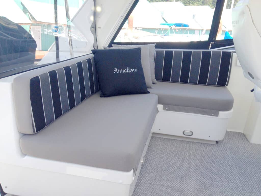 Cozy boat seating with striped cushions and pillow.