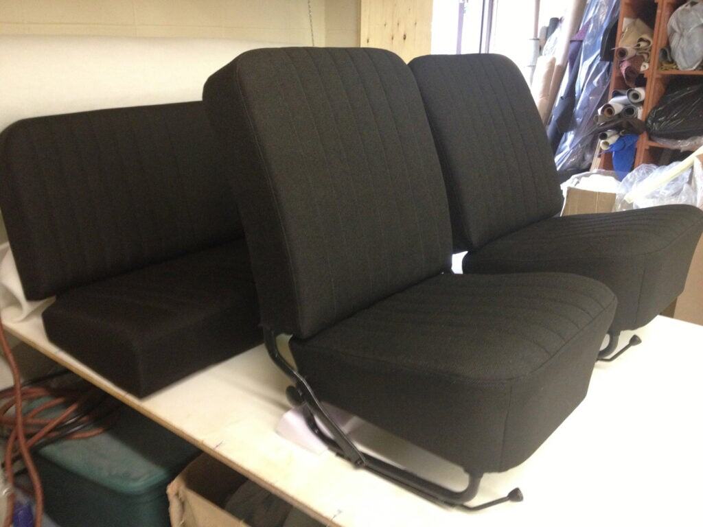 Black car bench and seat cushions on table.