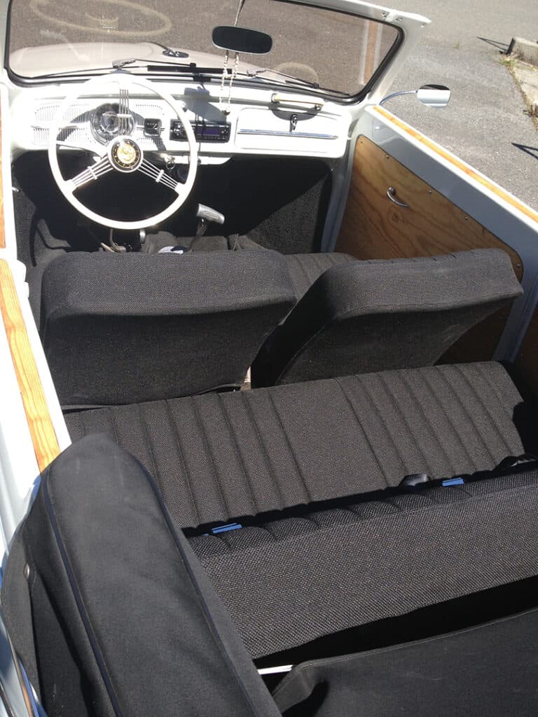Vintage car interior with white steering wheel.
