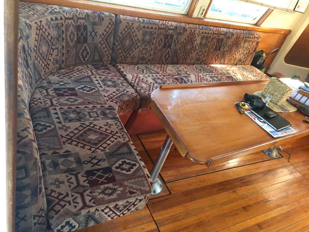 Cozy boat interior with patterned seating and table.