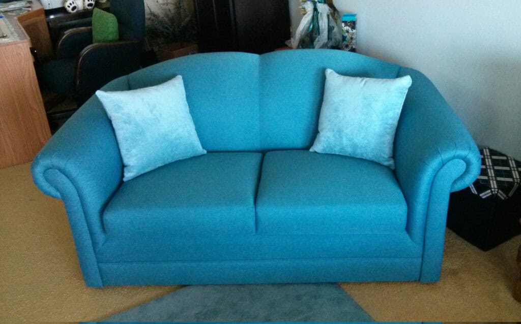 Blue sofa with two cushions in living room.
