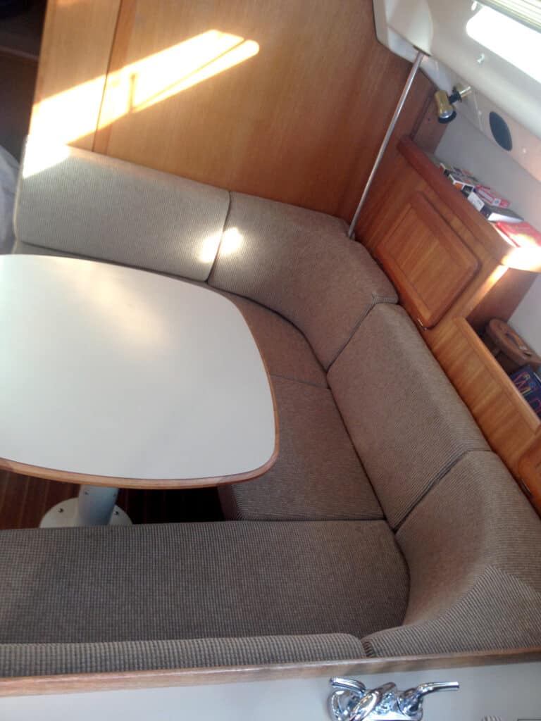Cozy boat cabin with table and seating area.