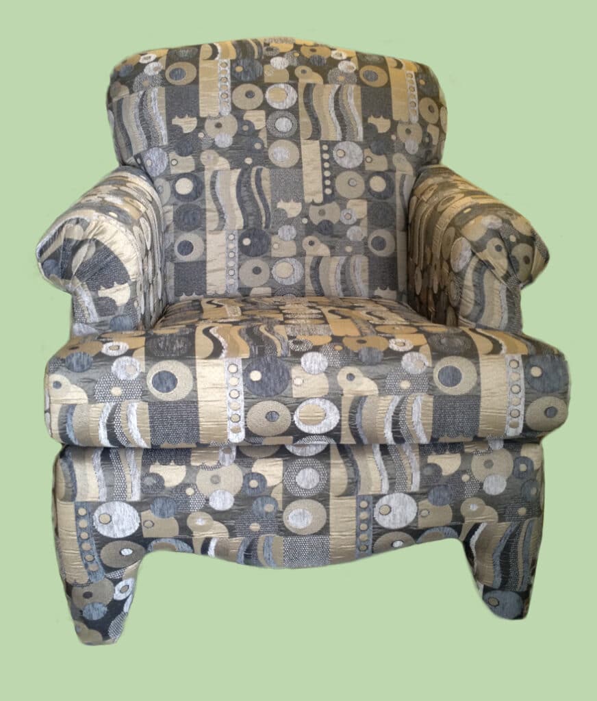Patterned grey armchair on green background.
