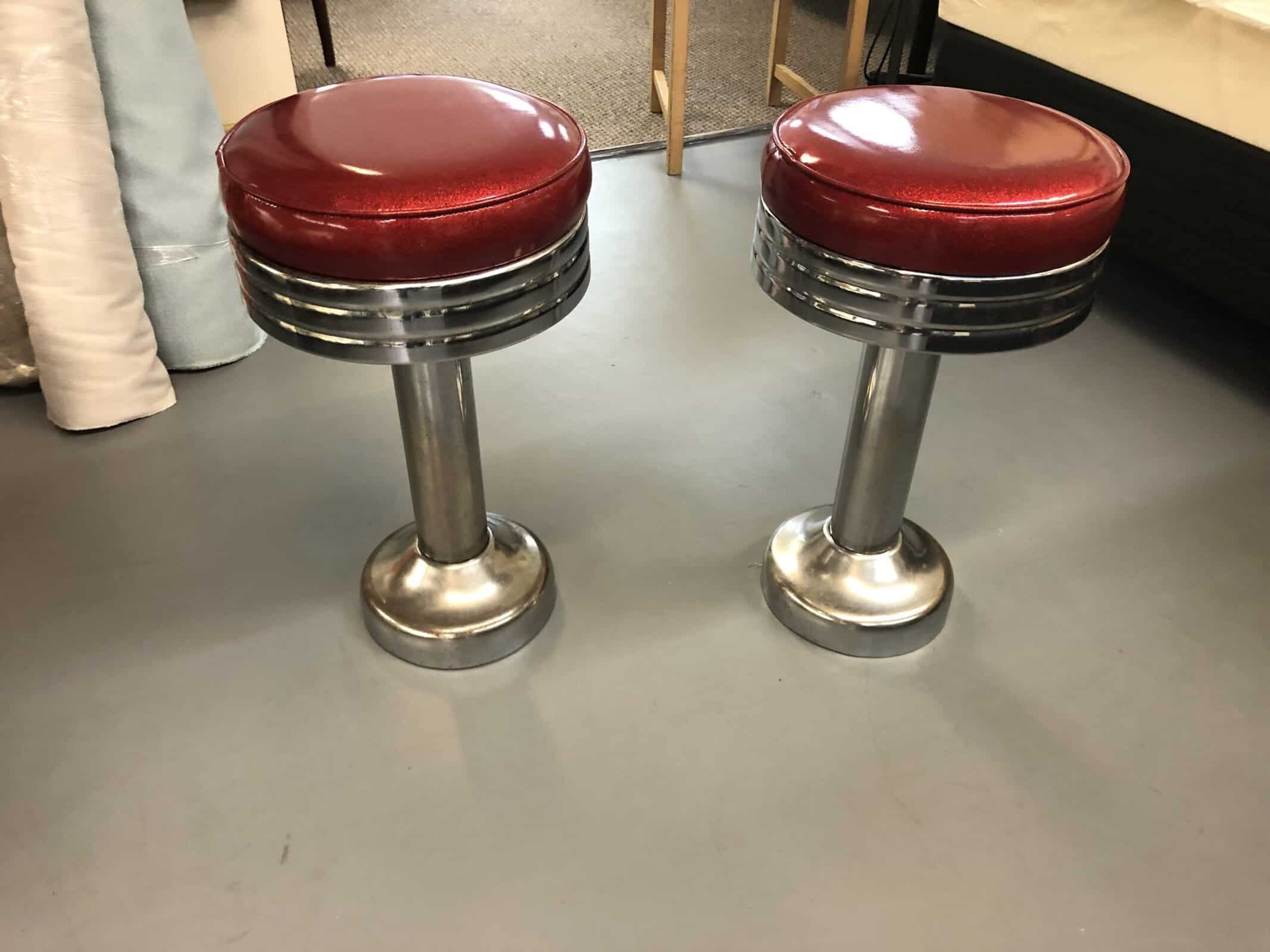 Two vintage diner stools with red seats