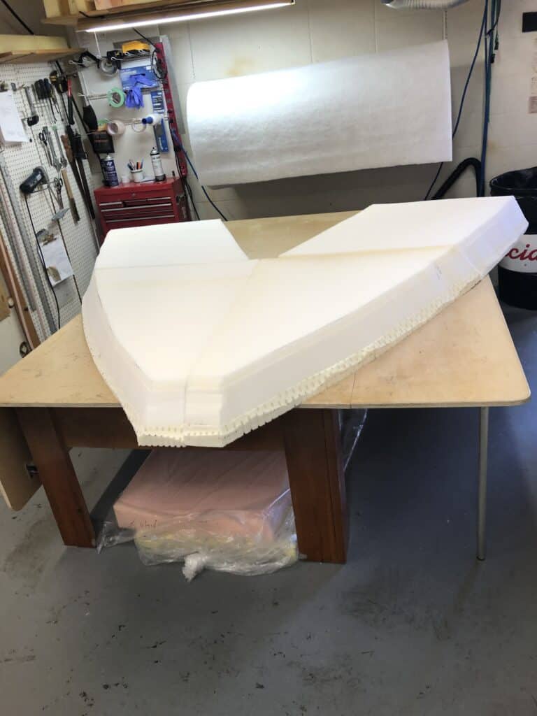Workshop with large foam model on table.