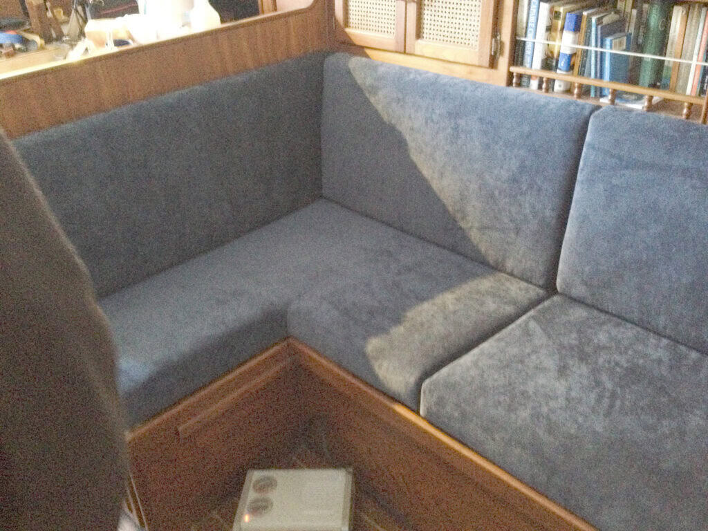 Blue L-shaped couch with bookshelves in background.