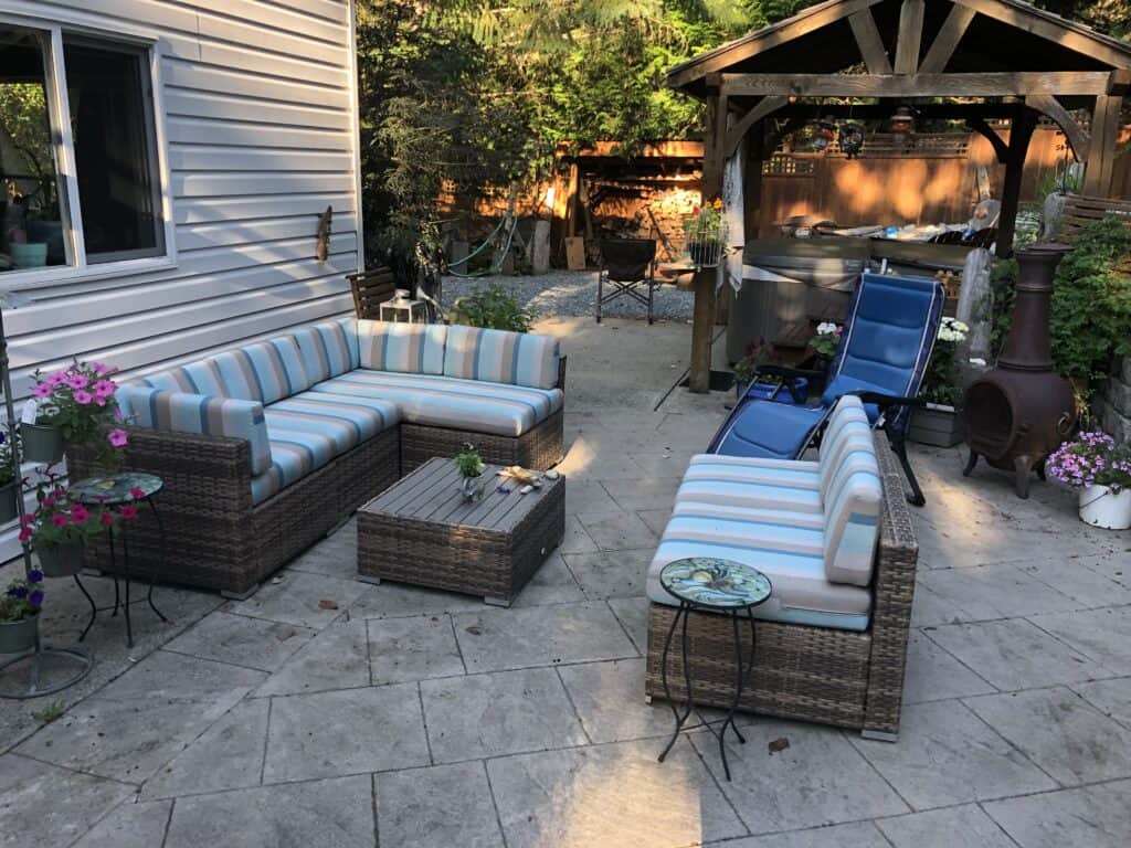 Patio with wicker furniture and striped cushions.