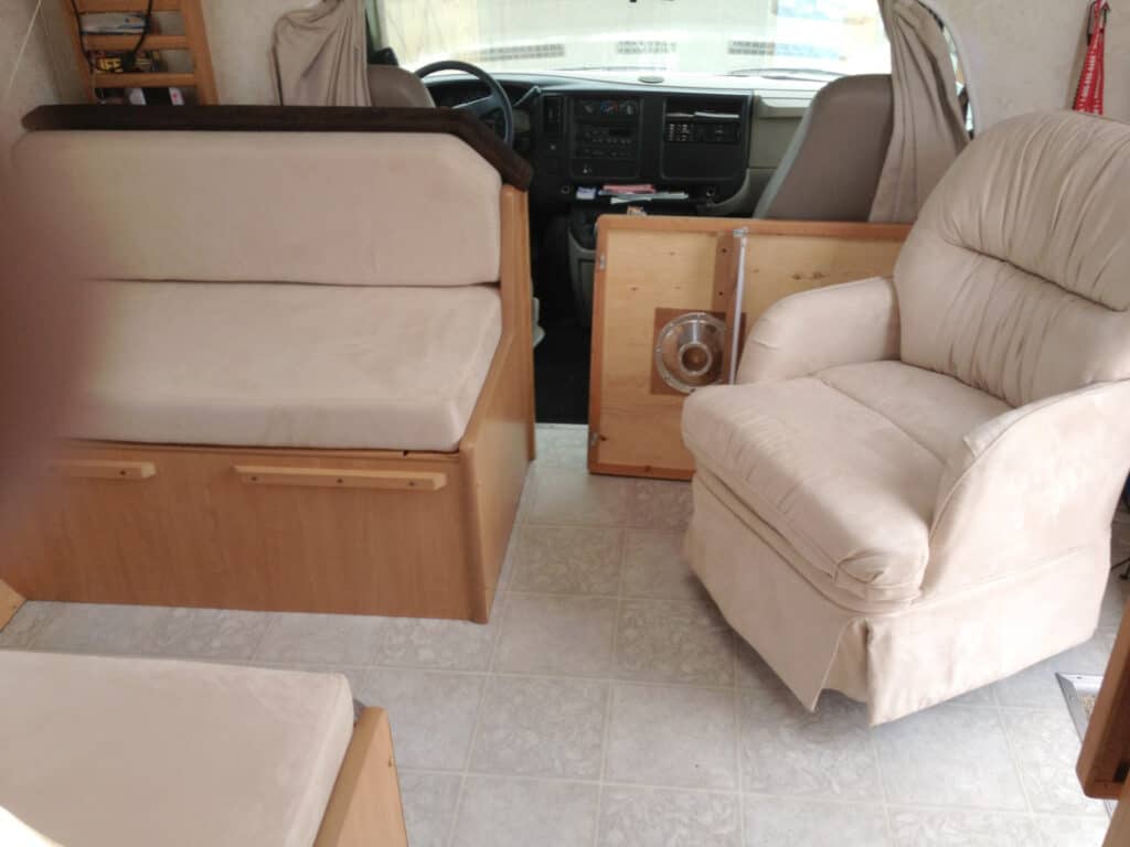 Motorhome interior with beige seating and dashboard view.