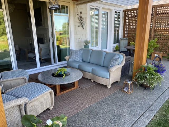 Cozy outdoor patio with wicker furniture and plants.
