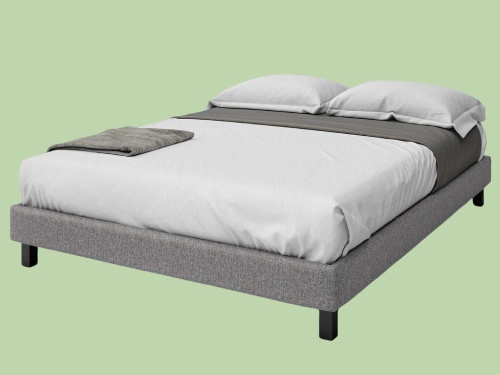 Grey bed with white sheets and pillows