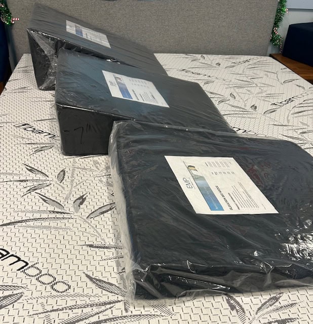 Three packaged items on a patterned mattress